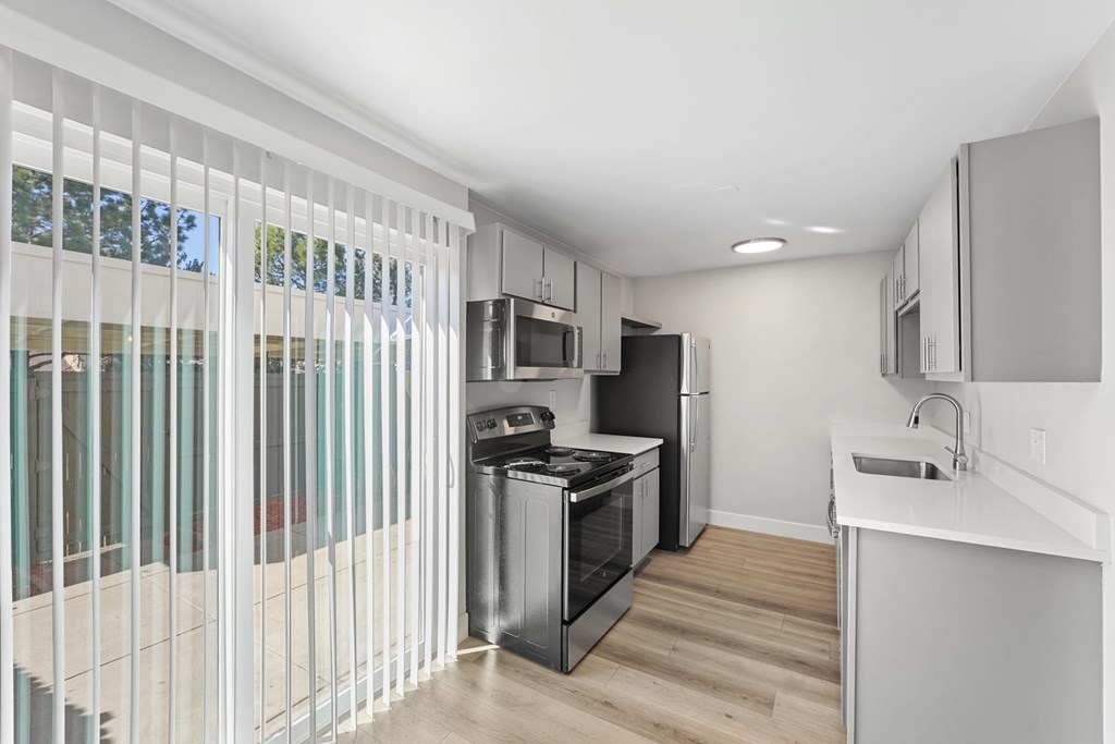 A modern kitchen with white cabinets and a stainless steel oven. A modern kitchen with white cabinets and a stainless steel oven. at The Lex At Lowry, Denver, Colorado