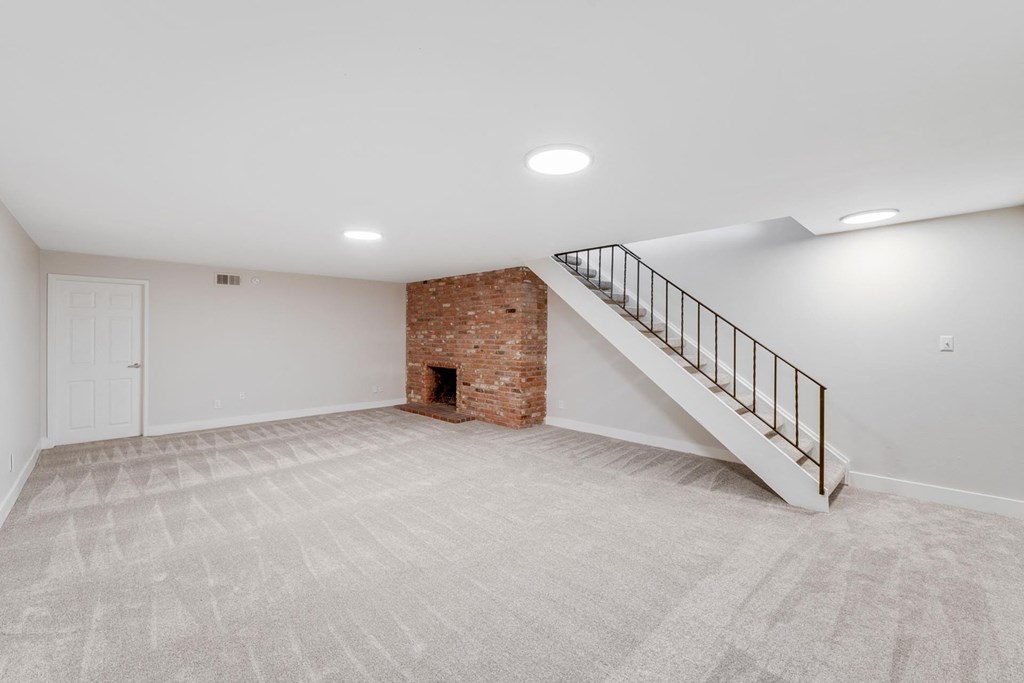 A room with a carpeted floor and a staircase leading to a loft. at The Lex At Lowry, Colorado