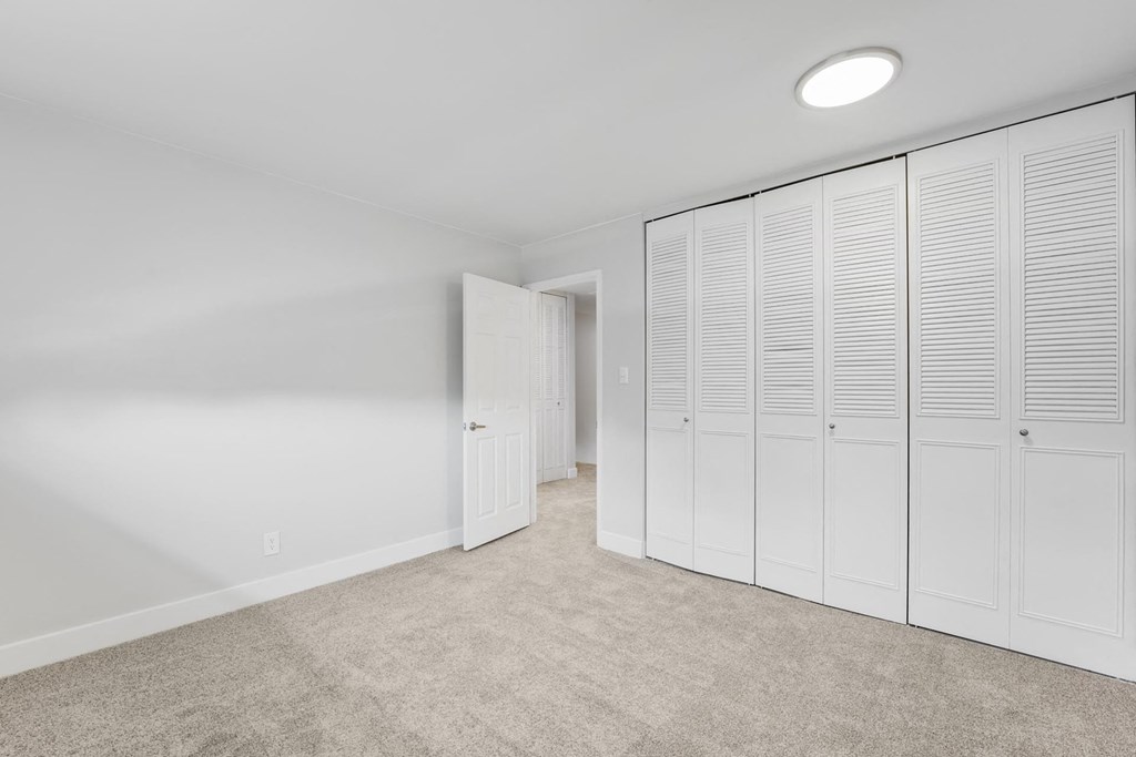 A room with white cupboards and a carpeted floor. at The Lex At Lowry, Denver, Colorado
