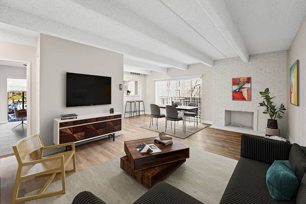 A living room with a fireplace and a television. at The Lex At Lowry, Denver, CO, 80224