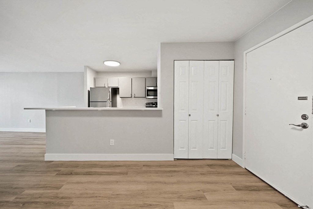A kitchen with white cabinets and a white door. at The Lex At Lowry, Denver, CO