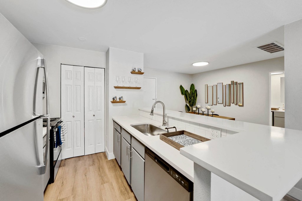 A modern kitchen with white countertops and a large island. at The Lex At Lowry, Denver, Colorado