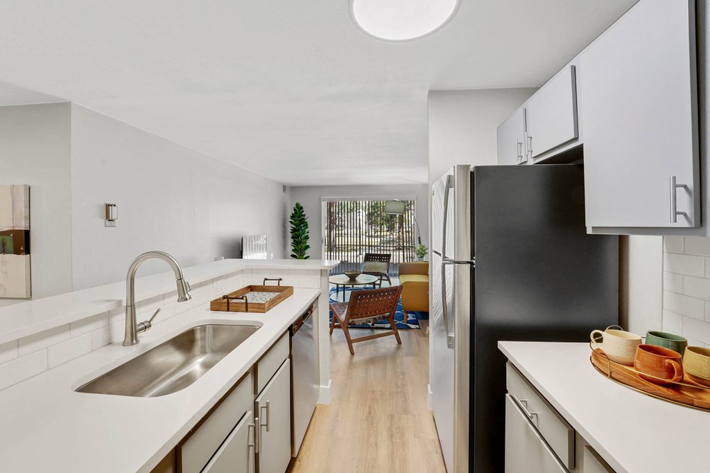 A modern kitchen with a black refrigerator and wooden floors. at The Lex At Lowry, Colorado, 80224