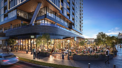 A modern building with a curved glass facade and a large outdoor seating area at The Mitchell in Downtown Atlanta