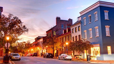 A street view of a city with cars parked on the side of the road.