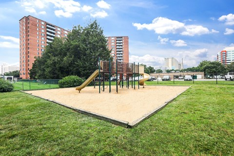 A playground with a slide and swings in a park.