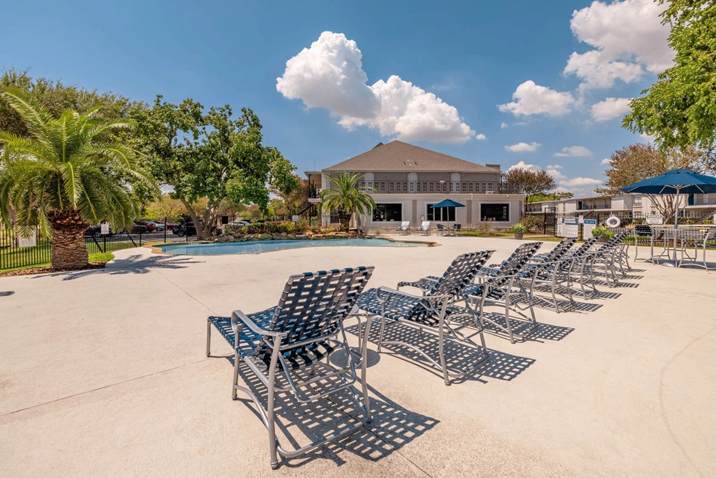 A row of metal chairs are lined up on a concrete surface.