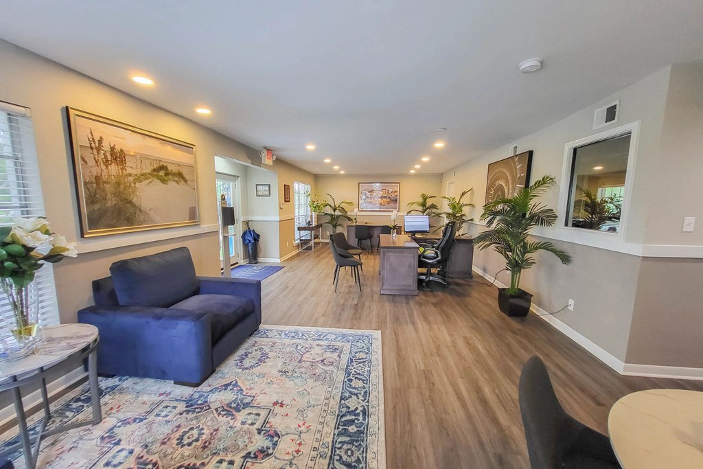 A living room with a blue couch and a rug.