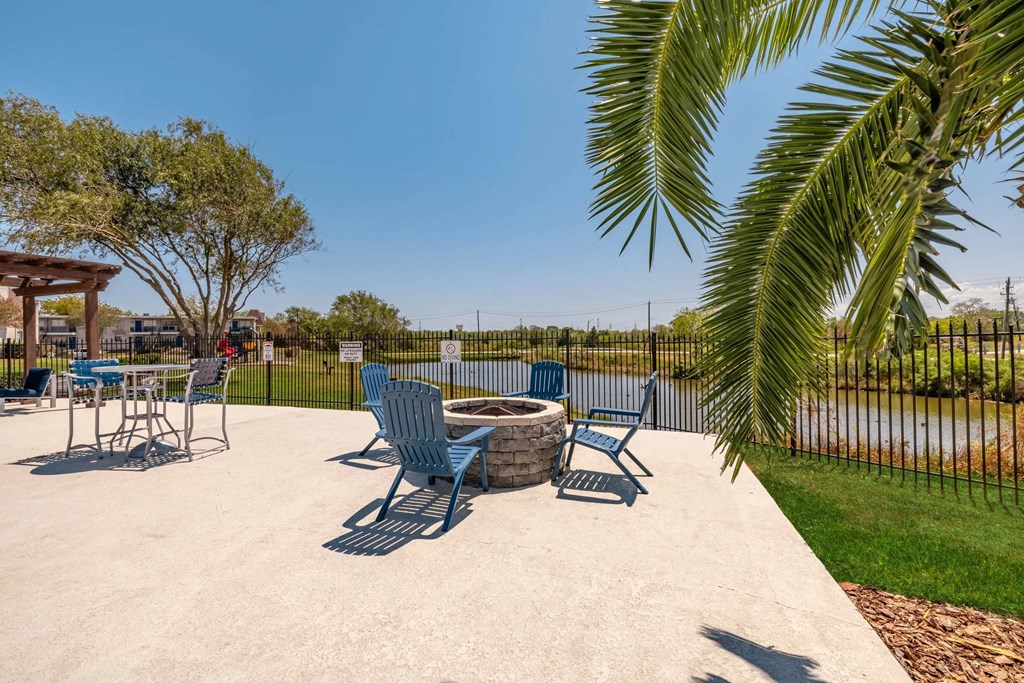 A concrete patio with blue chairs and a table.