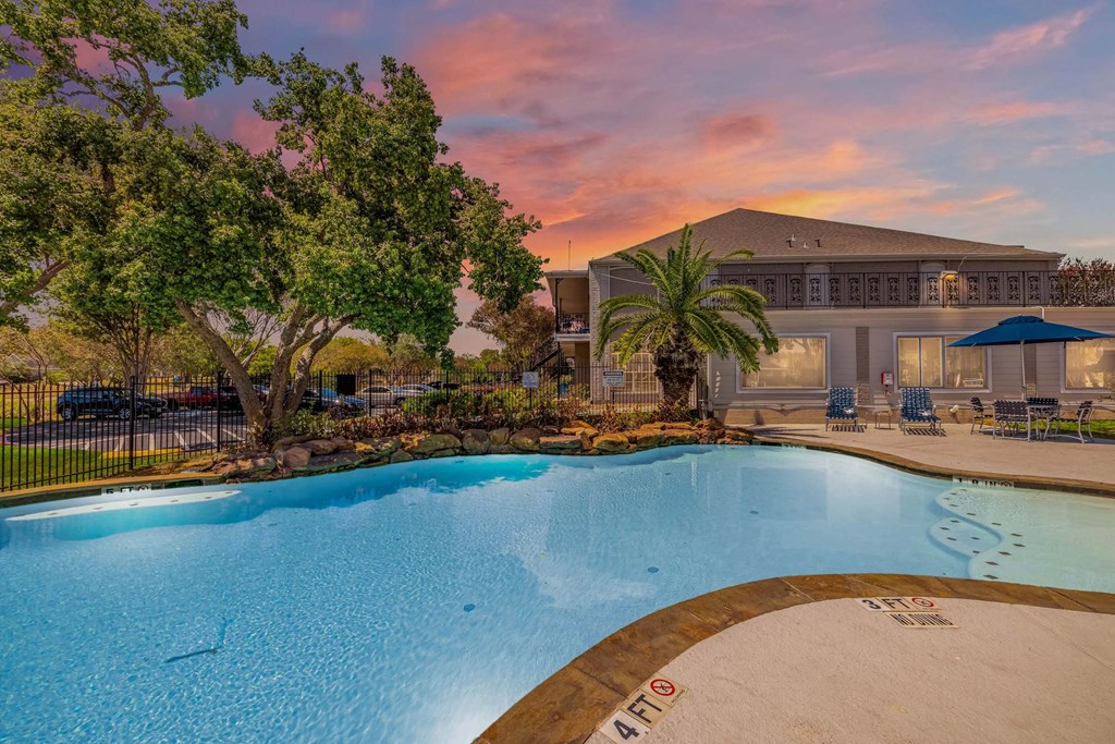 A swimming pool with a slide and a building in the background.