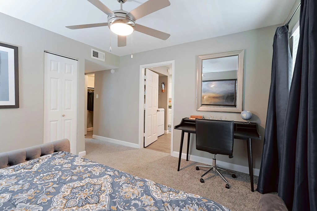 A bedroom with a bed, desk, and chair.