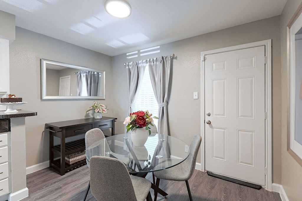 A dining room with a glass table and chairs.