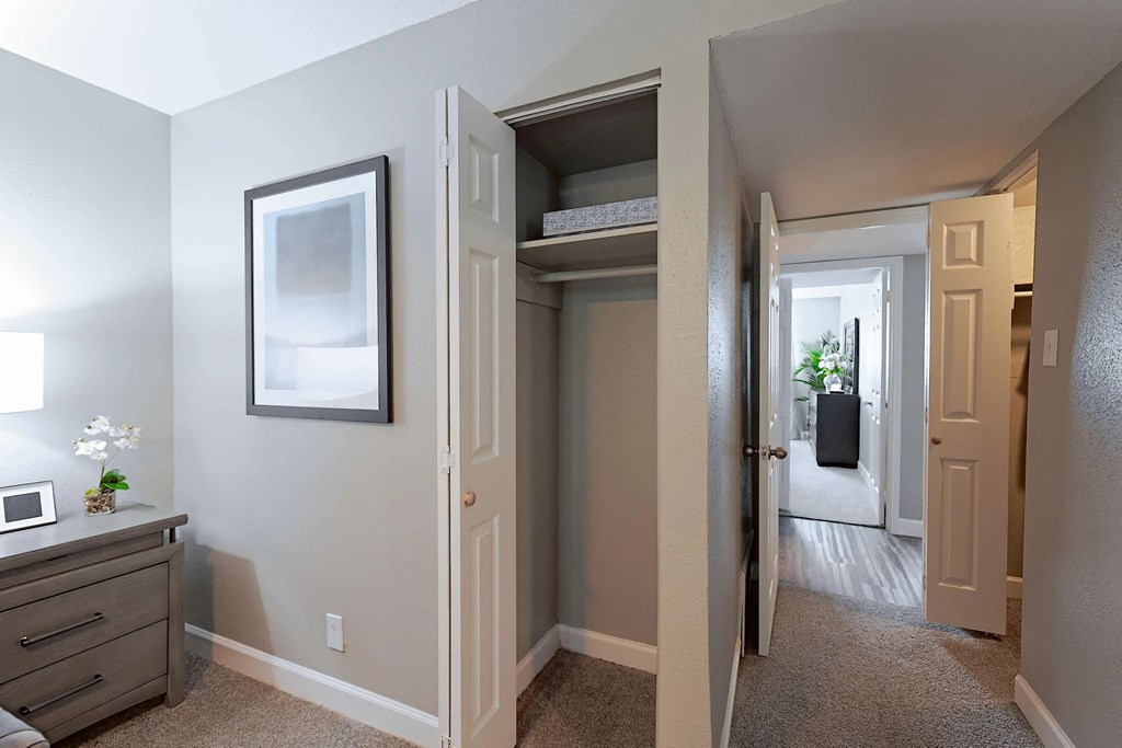 A hallway with a white door and a grey wall.