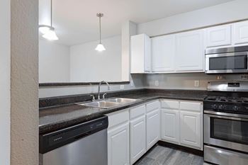 A kitchen with white cabinets and stainless steel appliances.