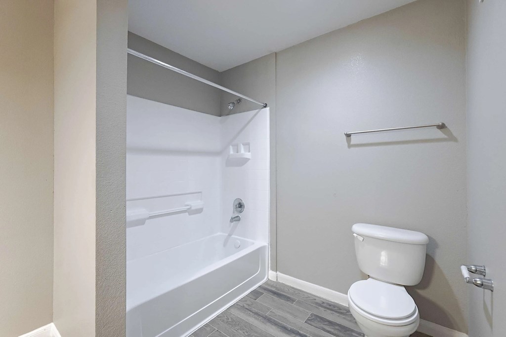 A white toilet sits next to a walk-in shower in a bathroom.