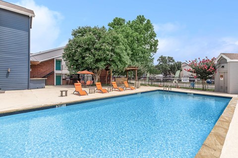 Resort style swimming pool with lounge chairs at Park at LeBlanc Apartments, Fort Worth, TX