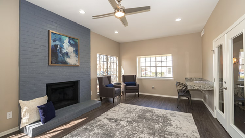 A living room with a fireplace and a painting on the wall.