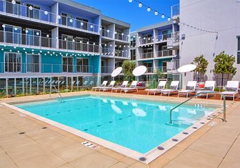 A large swimming pool in front of a multi-story apartment building.at Prizma, Los Angeles, CA  