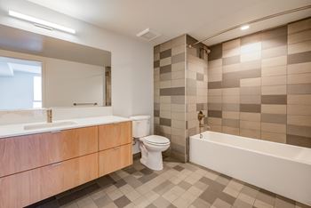 A bathroom with a white tub, sink, and toilet.at Prizma, California  