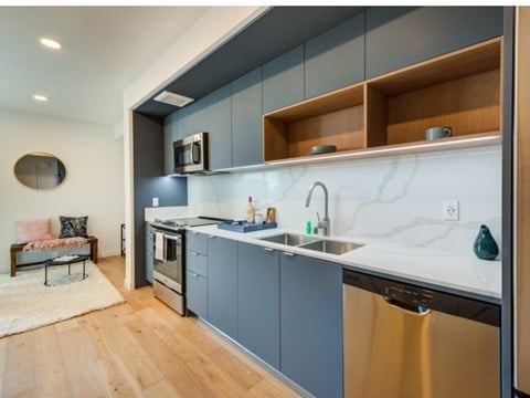 A modern kitchen with a stainless steel dishwasher and a marble backsplash. A modern kitchen with a stainless steel dishwasher and a marble backsplash.at Prizma, Los Angeles, CA
