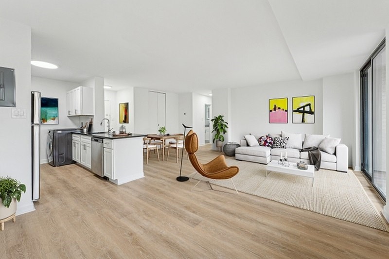 A modern living room with a white couch and a wooden chair.at Sherwood at Southern Towers, Alexandria, 22311