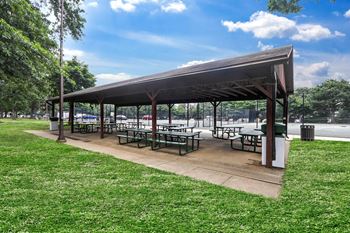 A covered picnic area with tables and benches is surrounded by green grass.at Sherwood at Southern Towers, Alexandria, VA 22311