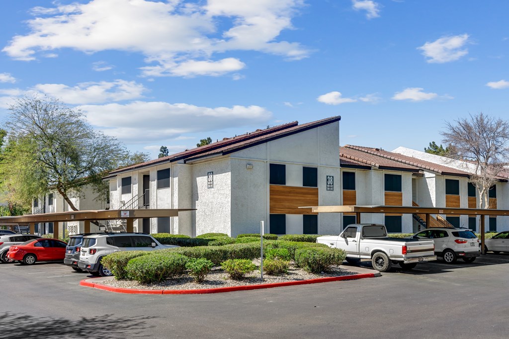 A parking lot with cars and a building at Solara, Phoenix, AZ 85033