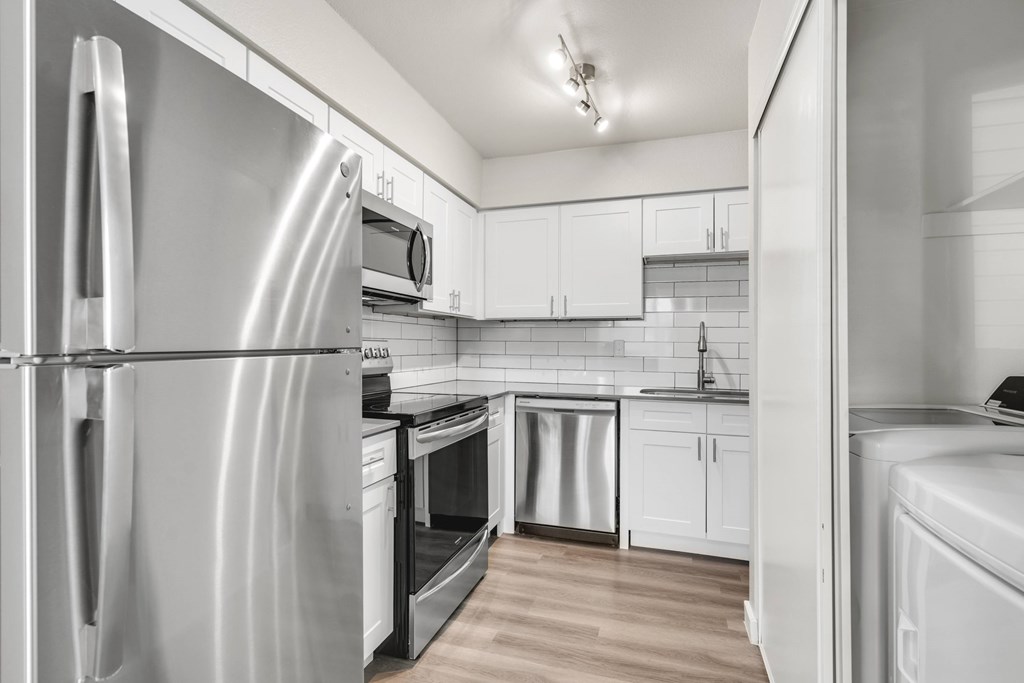A modern kitchen with a stainless steel refrigerator.at Solara, Phoenix, AZ 85033