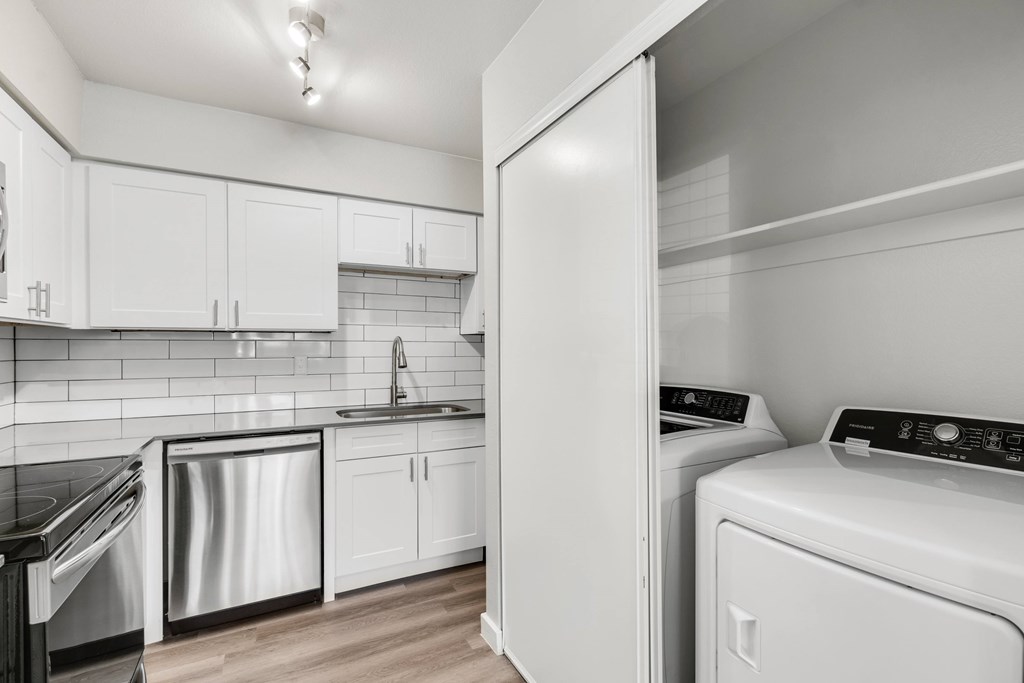 A modern kitchen with white appliances and cabinets.at Solara, Phoenix, AZ