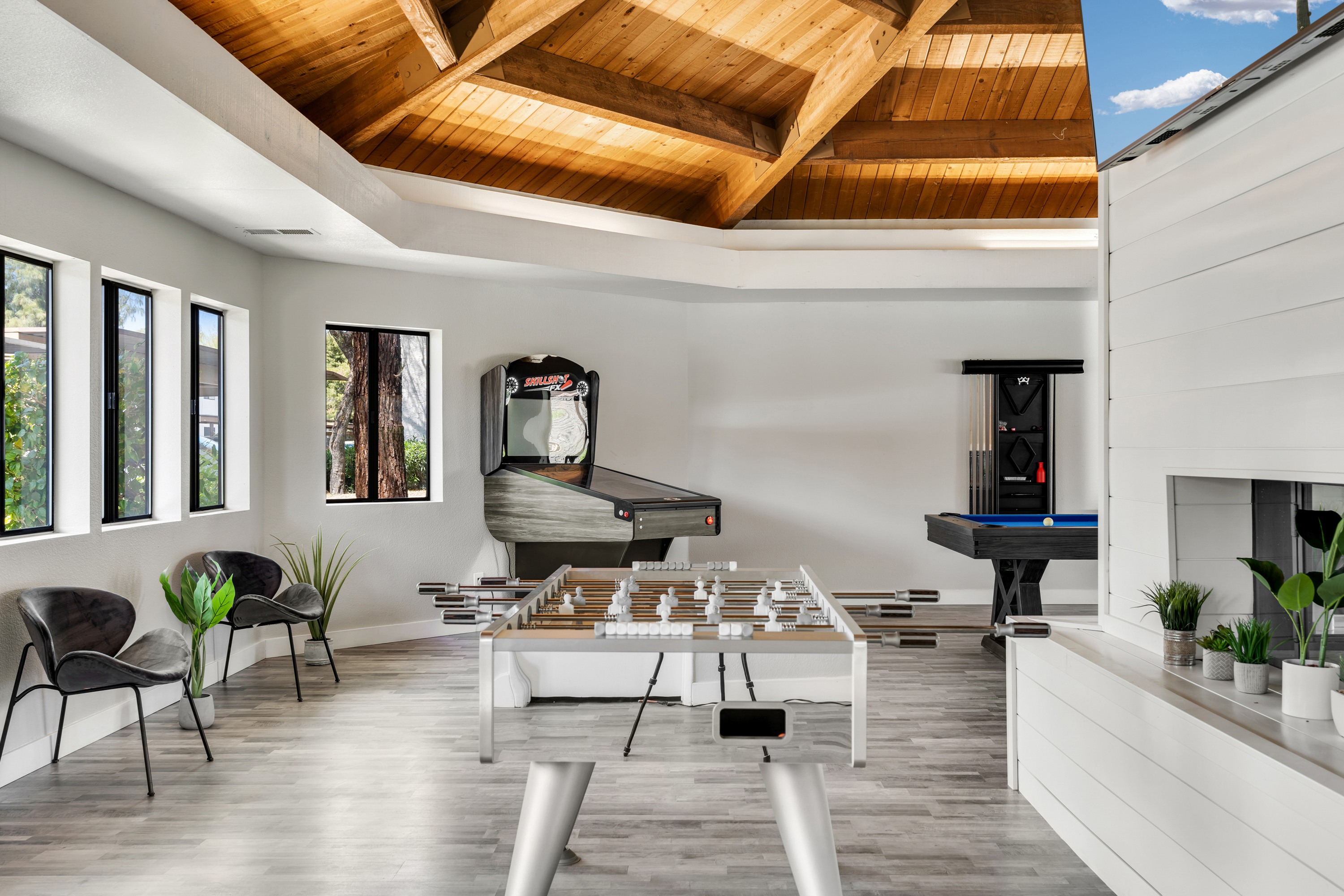 A modern living room with a pool table and a fireplace.