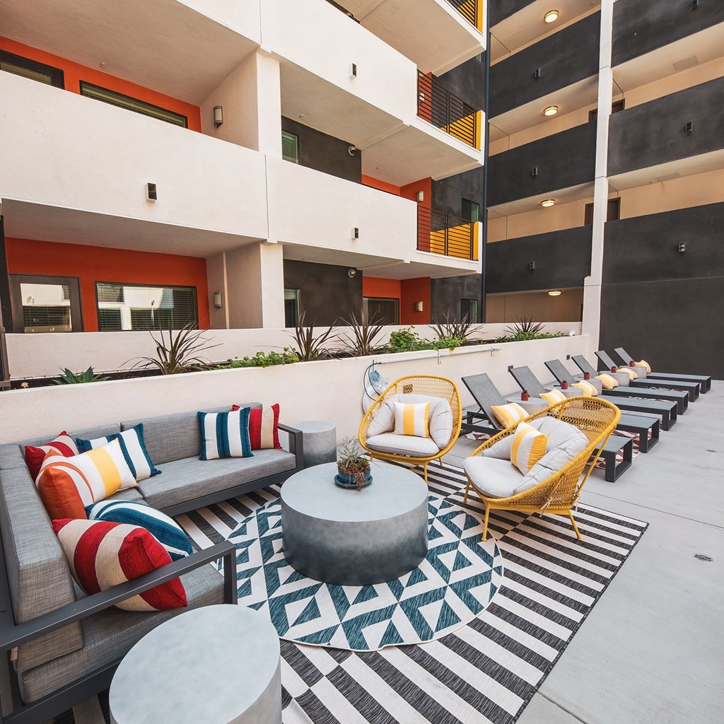 Patio with lounge chairs and couch at Sora Apartments, Inglewood