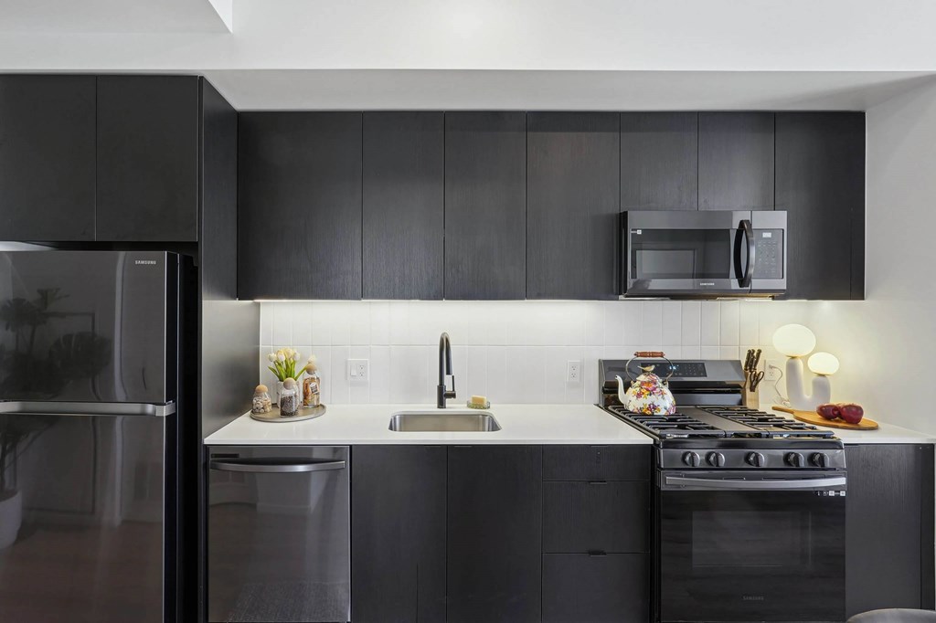 Modern kitchen with black refrigerator at Velaris Living Apartments, Colorado