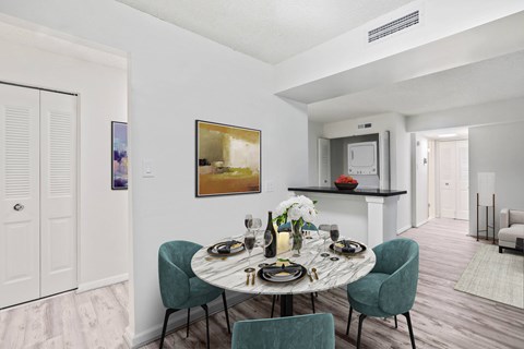A dining room with a round table set for two.