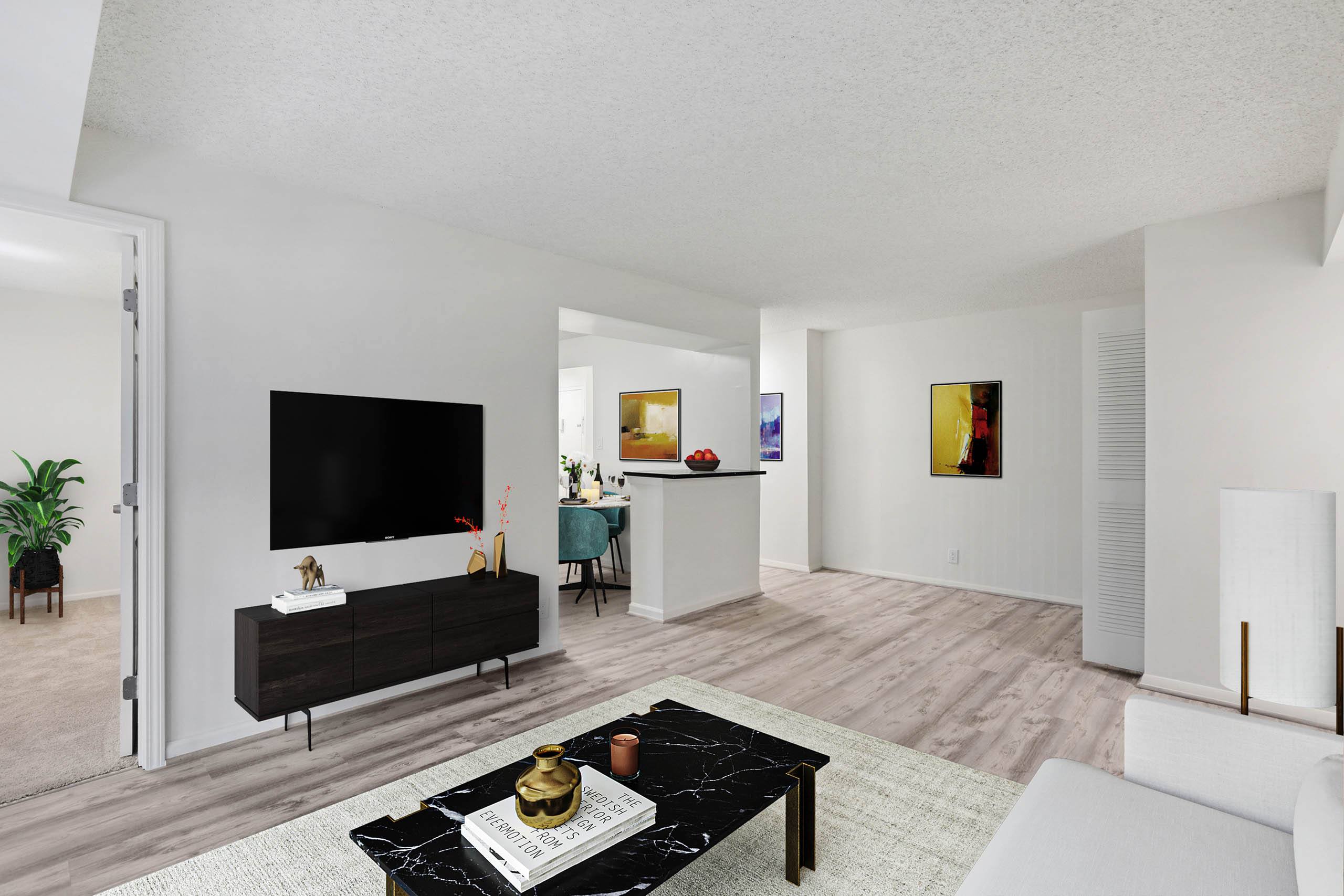 A modern living room with a black coffee table in the center.