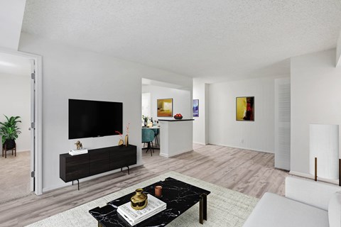 A modern living room with a black coffee table in the center.