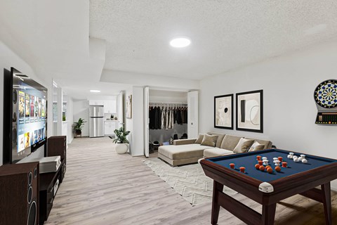 A pool table with a green cloth and white balls is in the center of the room.