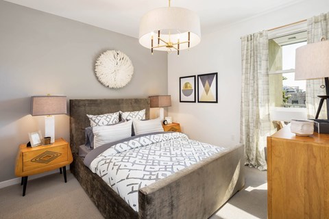 A bedroom with a large bed and a chandelier.