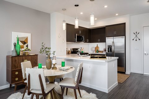 A modern kitchen with a dining table set for four.