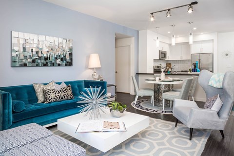 A modern living room with a blue couch and a white coffee table.