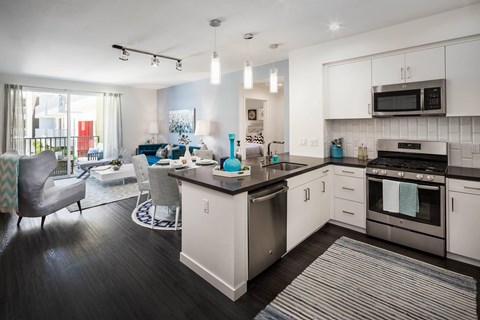 A modern kitchen with white cabinets and a black countertop.