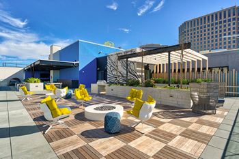 A modern outdoor seating area with yellow chairs and a white table.at Eleven Fifty Clay Street, California, 94607