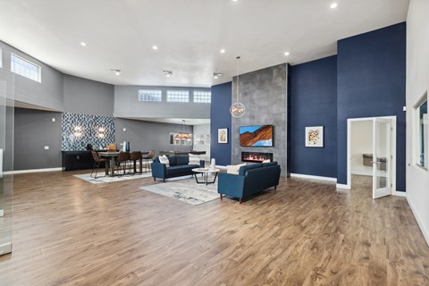 A living room with a blue couch and a wooden floor.