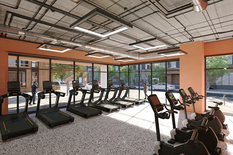 A gym with treadmills and a person walking by.