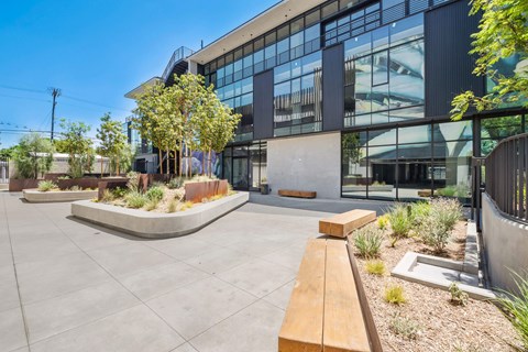 A modern building with a glass facade and a landscaped courtyard.