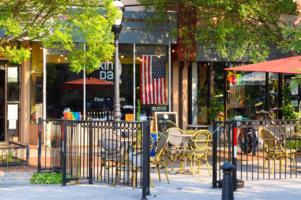 A restaurant with tables and chairs is surrounded by a black fence.at The Vale at the Parks, Washington District of Columbia  