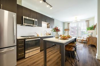 A modern kitchen with a dining table and chairs.at The Vale at the Parks, Washington District of Columbia  