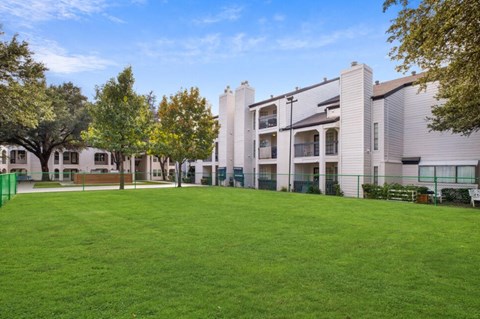 A grassy area in front of apartment buildings.