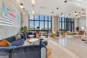 Modern living room with a large window at Velaris Living Apartments, Denver, CO