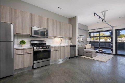 A modern kitchen with a refrigerator, oven, and microwave.