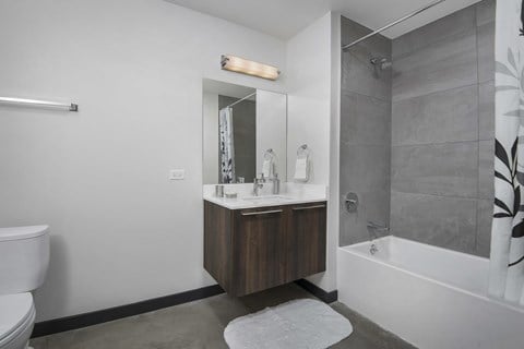 A bathroom with a white toilet, a sink with a mirror above it, and a shower area.